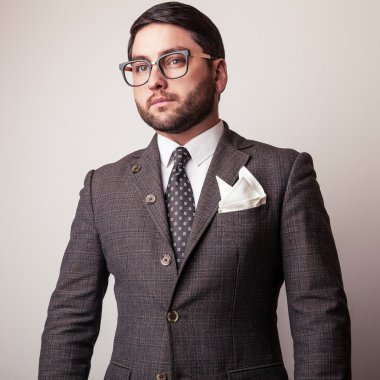 Gri kostümlü zarif genç yakışıklı adam. Studio moda portre.
