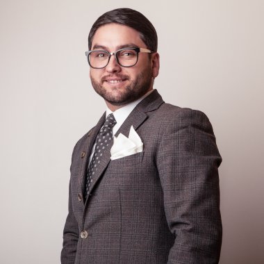 Gri kostümlü zarif genç yakışıklı adam. Studio moda portre.