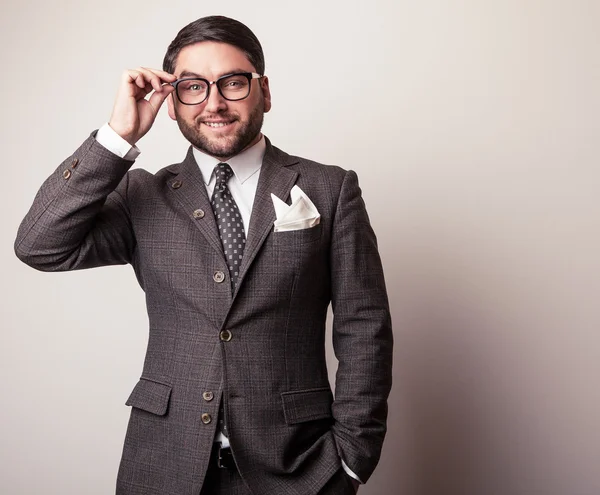 Elegante jonge knappe man in grijs kostuum. Studio mode portret. — Stockfoto