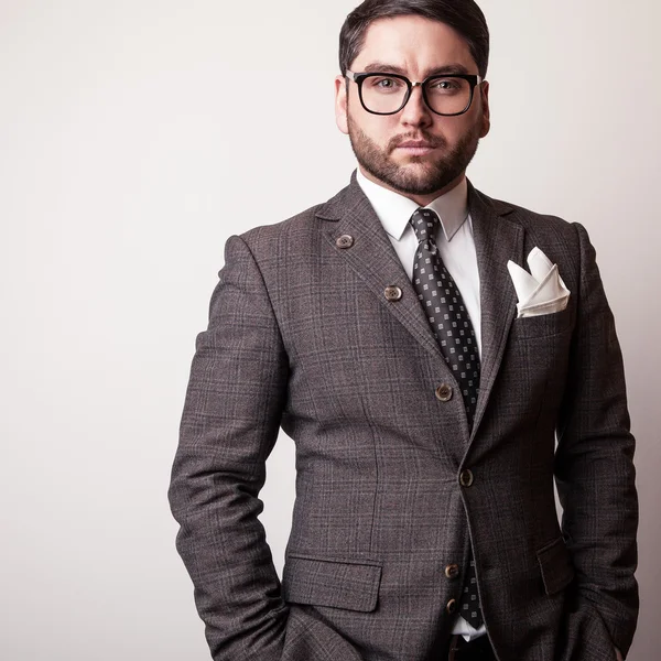 Elegante jovem e bonito homem de fato cinzento. Estúdio retrato de moda . — Fotografia de Stock