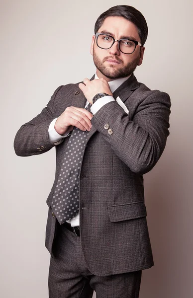 Elegante jovem e bonito homem de fato cinzento. Estúdio retrato de moda . — Fotografia de Stock