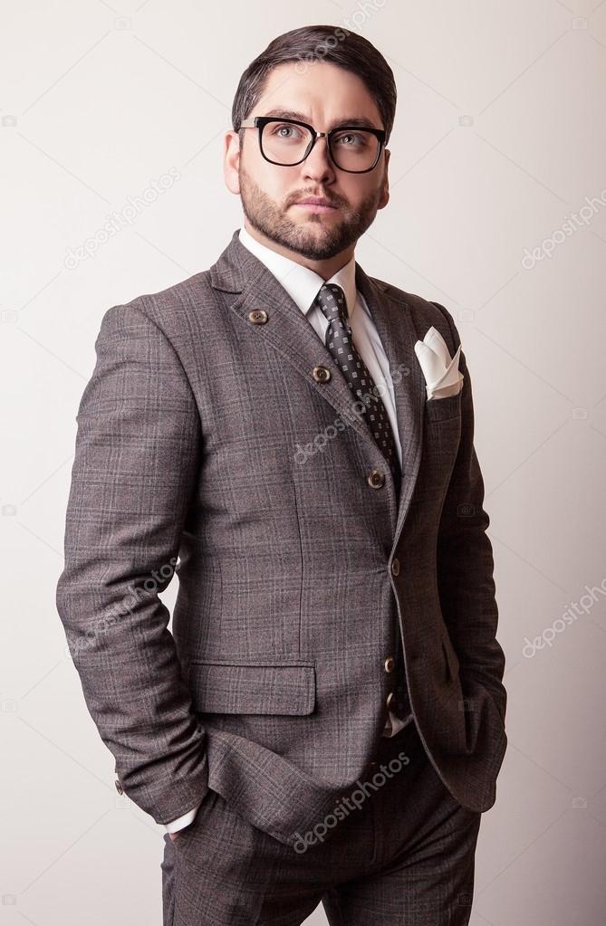 Elegant young handsome man in grey costume. Studio fashion portrait.