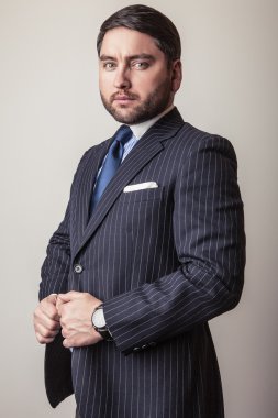 Lüks koyu mavi kostüm zarif genç yakışıklı adam. Studio moda portre.