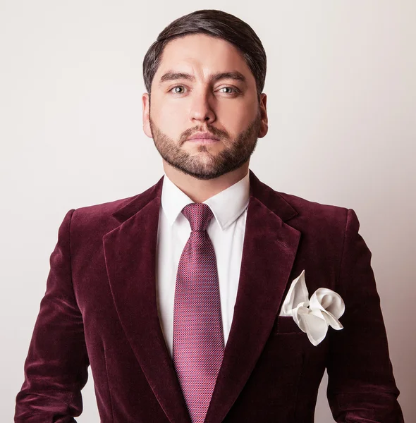 Elegante joven guapo hombre en traje de terciopelo de lujo clarete. Estudio retrato de moda . —  Fotos de Stock