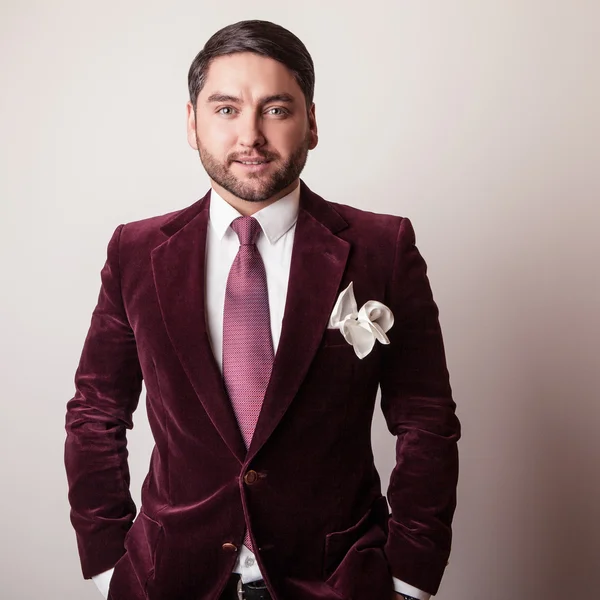 Elegant young handsome man in luxury velvet claret costume. Studio fashion portrait. — Stock Photo, Image