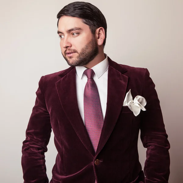 Elegante jonge knappe man in luxe fluweel claret kostuum. Studio mode portret. — Stockfoto