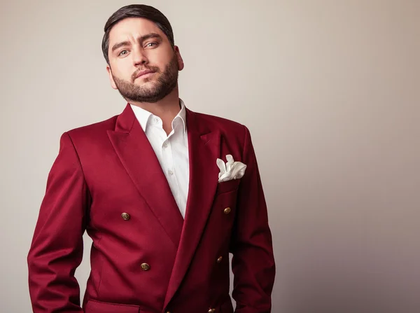 Elegante jovem homem bonito em fantasia de luxo vermelho. Estúdio retrato de moda . — Fotografia de Stock