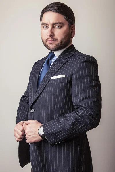 Elegant young handsome man in luxury dark blue costume. Studio fashion portrait. — Stock Photo, Image