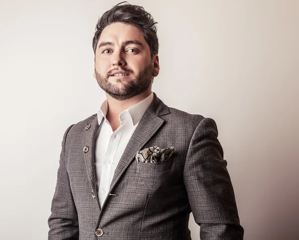 Elegante jovem e bonito homem de fato cinzento. Estúdio retrato de moda . — Fotografia de Stock