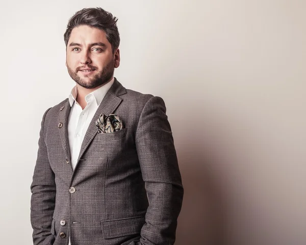 Elegante joven guapo en traje gris. Estudio retrato de moda . —  Fotos de Stock