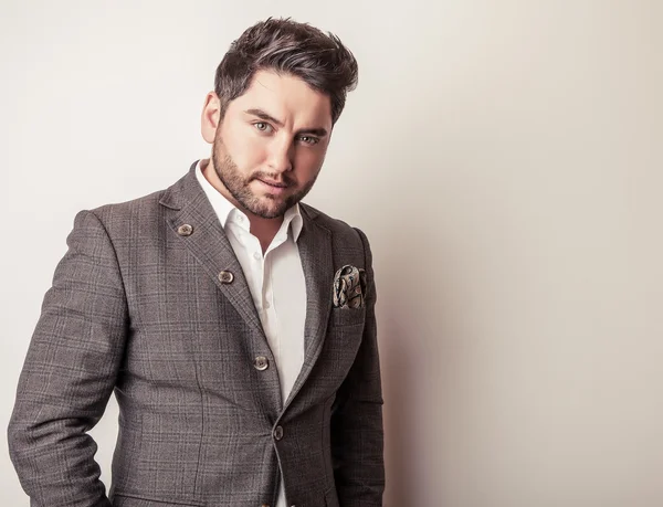 Elegante joven guapo en traje gris. Estudio retrato de moda . — Foto de Stock