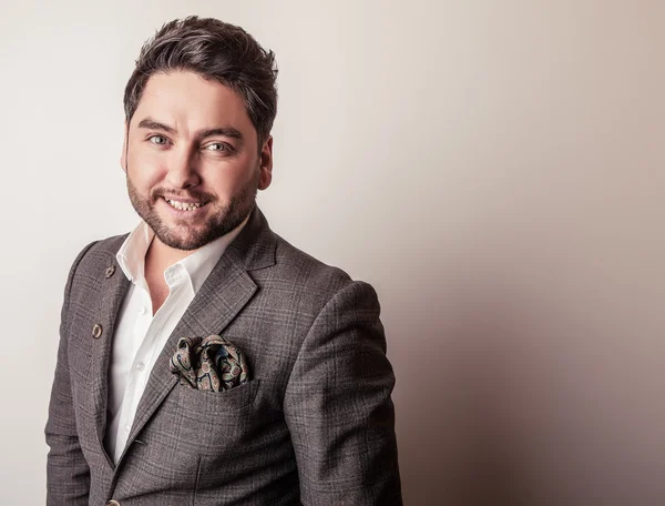 Elegante jovem e bonito homem de fato cinzento. Estúdio retrato de moda . — Fotografia de Stock