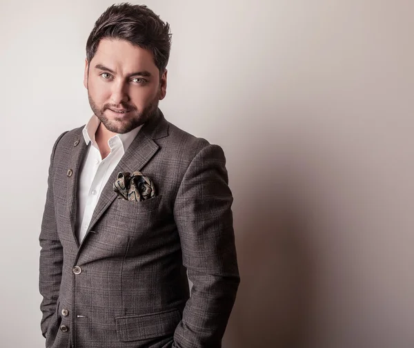 Elegante jovem e bonito homem de fato cinzento. Estúdio retrato de moda . — Fotografia de Stock