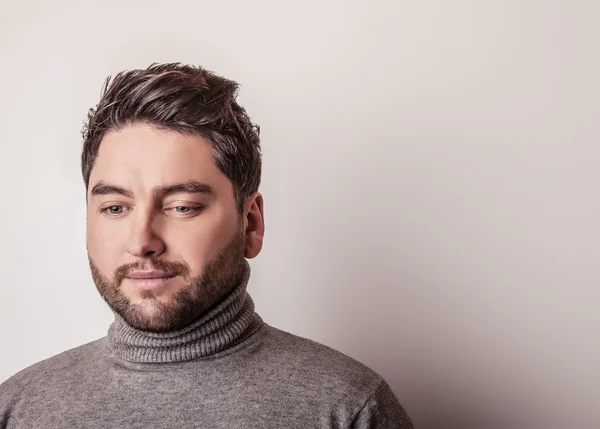 Elegante joven guapo hombre en suéter gris. Estudio retrato de moda . —  Fotos de Stock