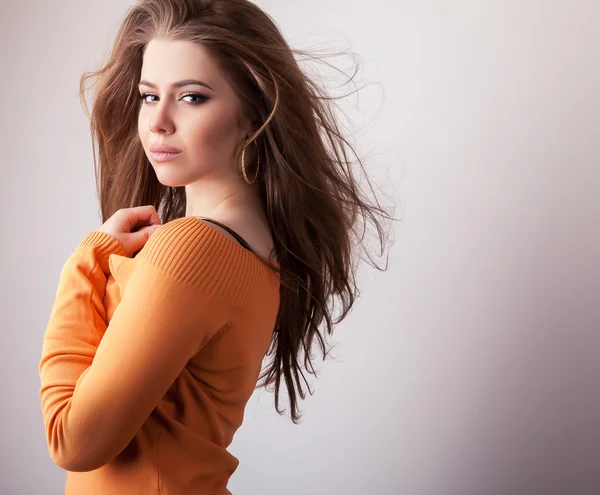 Młody zmysłowy idealna uroda wzór dziewczynka iin dorywczo pomarańczowy sweter pozować w studio. — Zdjęcie stockowe