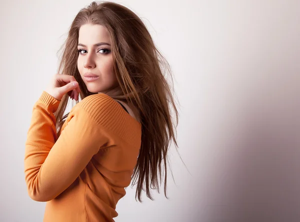 Young sensuell & skönhet modell flicka iin casual orange tröja posera i studio. — Stockfoto