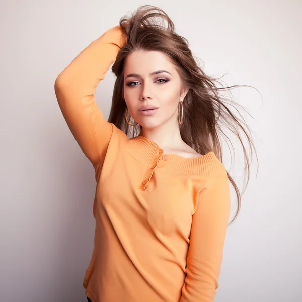 Jovem sensual & beleza modelo menina iin casual laranja suéter pose no estúdio . — Fotografia de Stock
