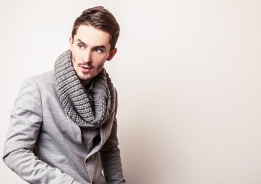 Gri kostümlü zarif genç yakışıklı adam. Studio moda portre.