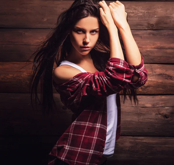 グランジの木製の背景にカジュアルな服装ポーズ & 官能的な美しさの若い女性. — ストック写真
