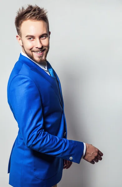 Elegante e amichevole giovane bell'uomo in costume blu. Studio ritratto di moda . — Foto Stock