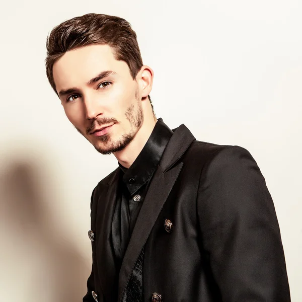 Elegante jovem bonitão vestido de preto. Estúdio retrato de moda . — Fotografia de Stock