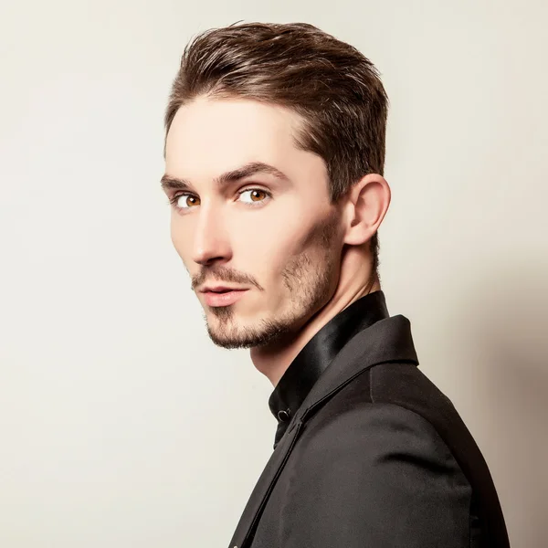 Elegante jovem bonitão vestido de preto. Estúdio retrato de moda . — Fotografia de Stock