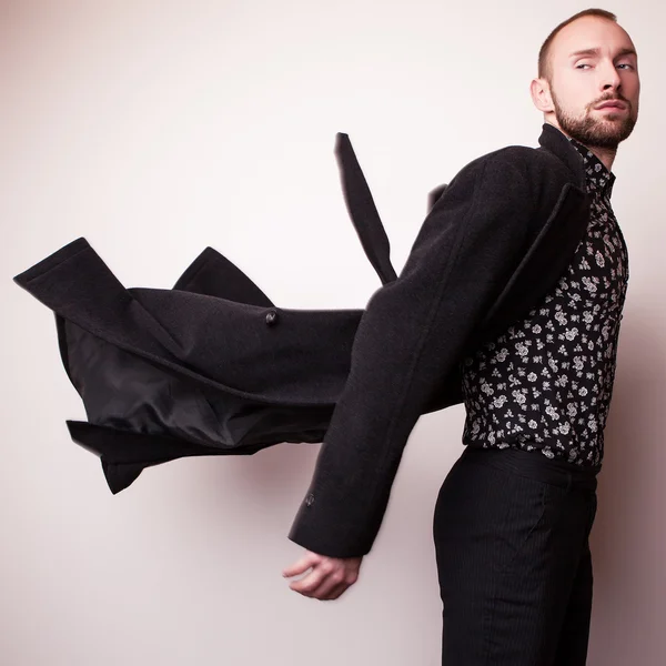 Elegante jonge knappe man in lang wollen jas. Studio mode portret. — Stockfoto