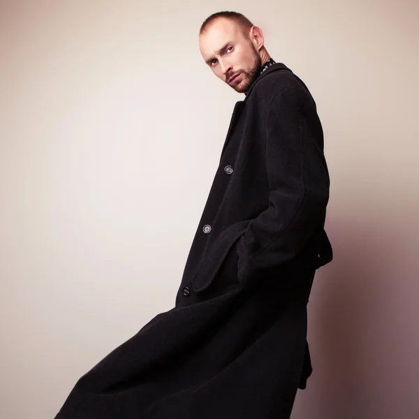 Elegante giovane bell'uomo in lungo cappotto di lana. Studio ritratto di moda . — Foto Stock