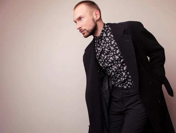 Eleganter junger gutaussehender Mann in langem Wollmantel. Modeporträt im Studio. — Stockfoto