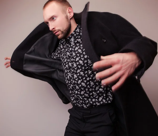 Elegante jonge knappe man in lang wollen jas. Studio mode portret. — Stockfoto