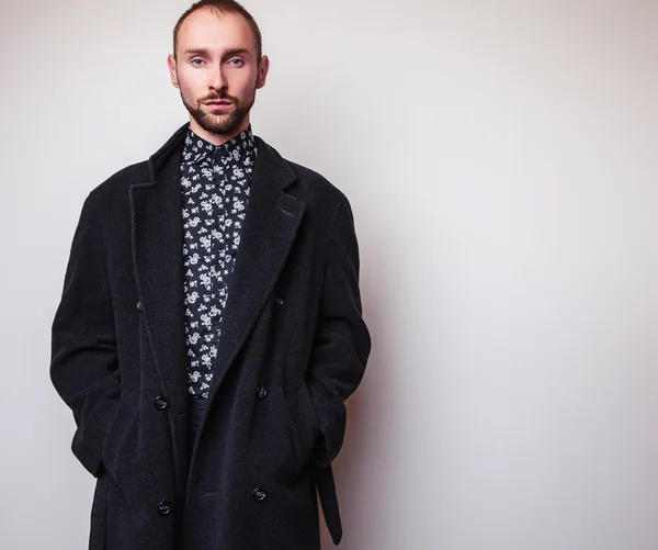 Elegante giovane bell'uomo in lungo cappotto di lana. Studio ritratto di moda . — Foto Stock