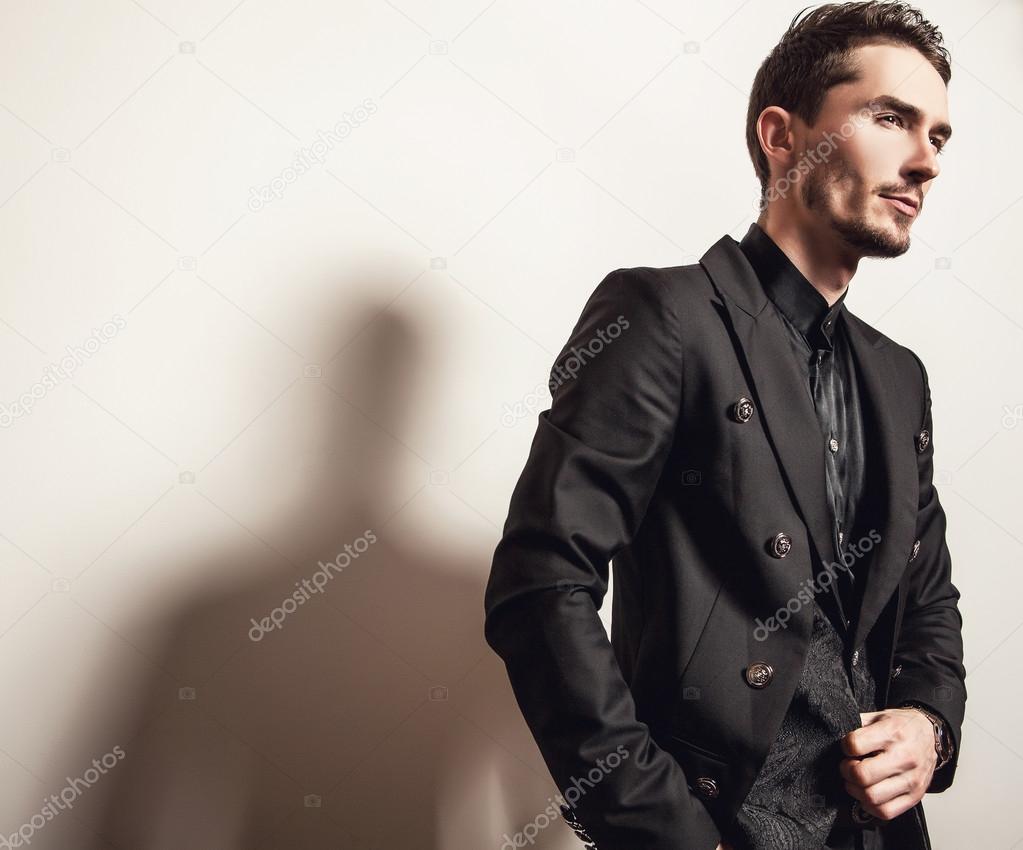 Элегантный молодой красивый мужчина в черном костюме