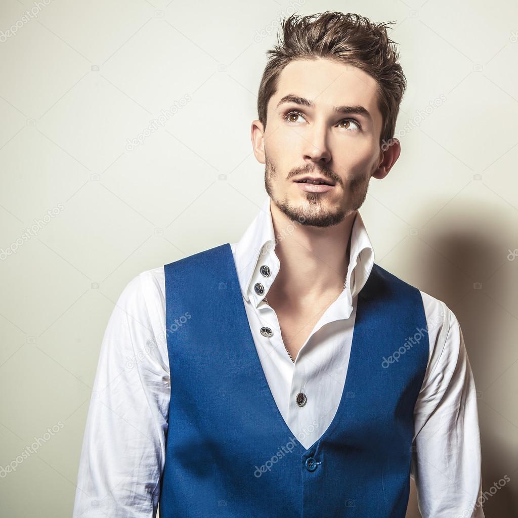 Elegant young handsome man in white shirt & vest. Studio fashion portrait.