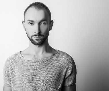 Siyah-beyaz stüdyo örme kazak genç yakışıklı adam portresi. Yakın çekim fotoğraf.