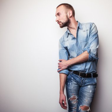 Kot pantolon giysili genç yakışıklı adam. Studio moda portre.