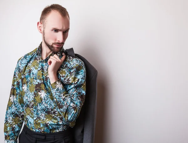 Elegante jonge knappe man in heldere kleurrijke shirt. Studio mode portret. — Stockfoto