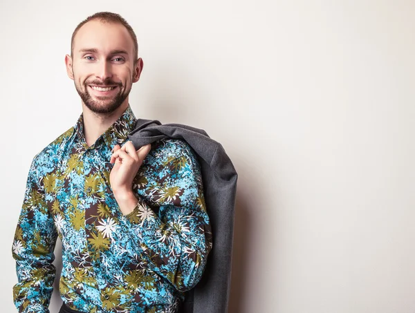 Elegantní mladý pohledný muž v zářivě barevné košile. Portrét módní Studio. — Stock fotografie