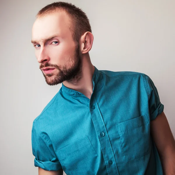 Elegante jonge knappe man in heldere kleurrijke shirt. Studio mode portret. — Stockfoto