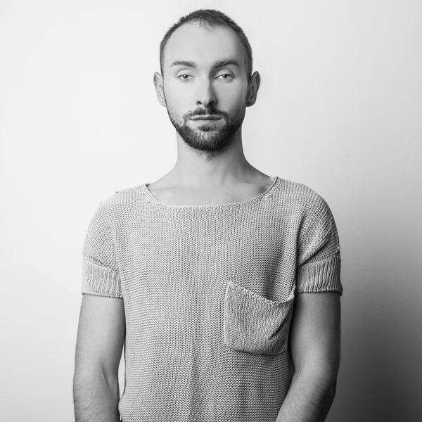 Černo bílé studiový portrét pohledný mladík v pletený svetr. Detail fotografie. — Stock fotografie