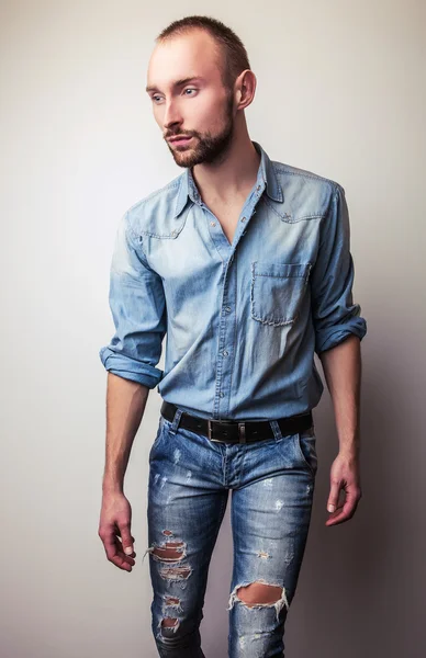 Junger gutaussehender Mann in Jeans-Kleidung. Modeporträt im Studio. — Stockfoto