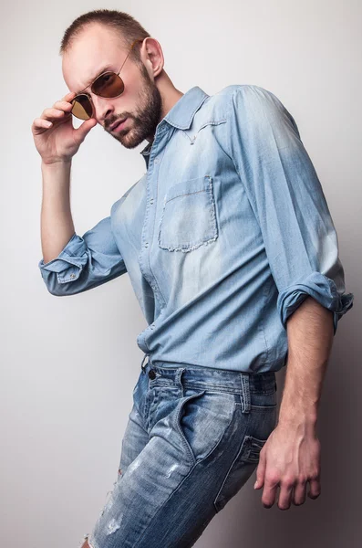 Mladý pohledný muž v džínách oblečení. Portrét módní Studio. — Stock fotografie