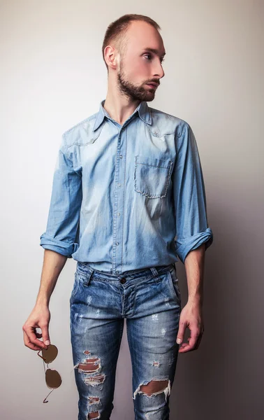Mladý pohledný muž v džínách oblečení. Portrét módní Studio. — Stock fotografie