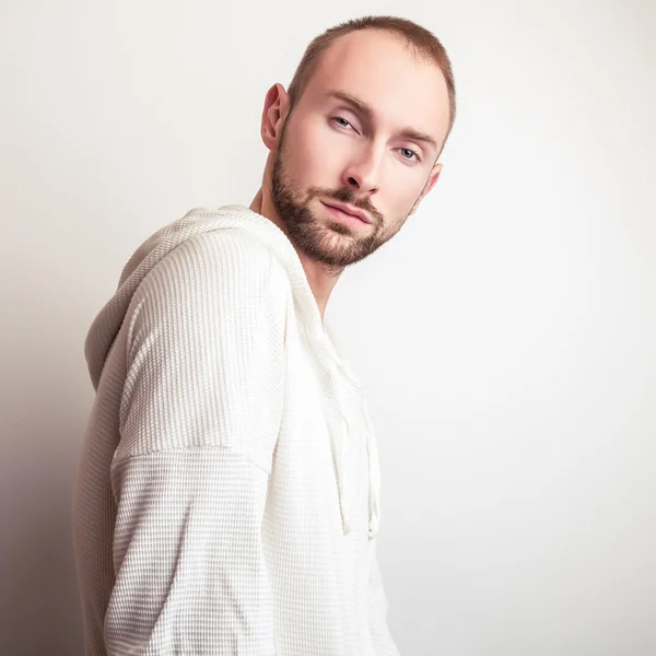 Retrato de estudio de un joven guapo en suéter blanco con capucha . —  Fotos de Stock