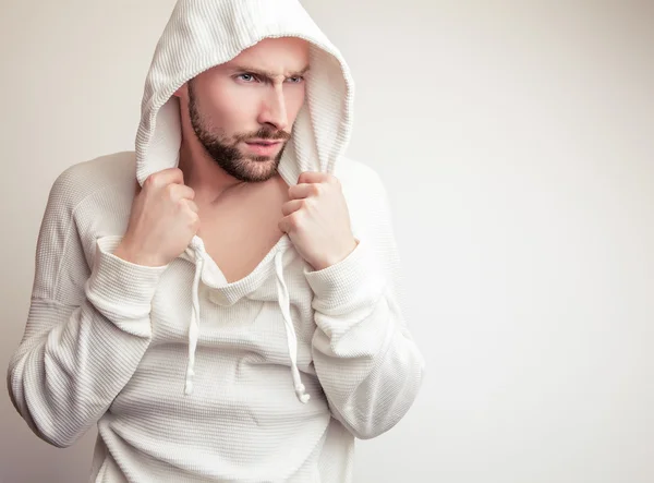 Studio portrait of young handsome man in white sweater with hood. — Stock Photo, Image