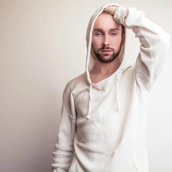 Estúdio retrato de jovem bonito homem em suéter branco com capuz . — Fotografia de Stock