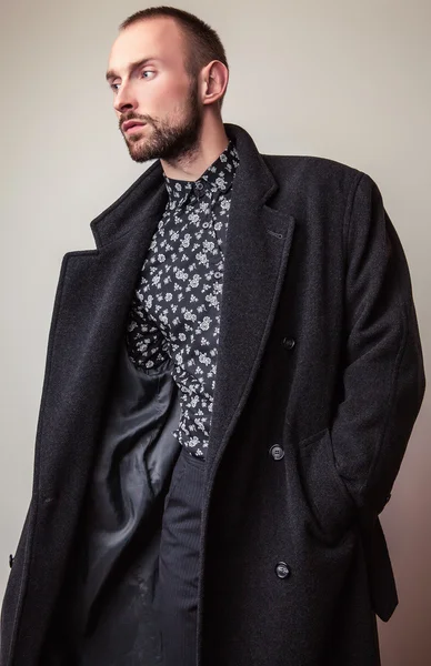 Eleganter junger gutaussehender Mann in langem Wollmantel. Modeporträt im Studio. — Stockfoto