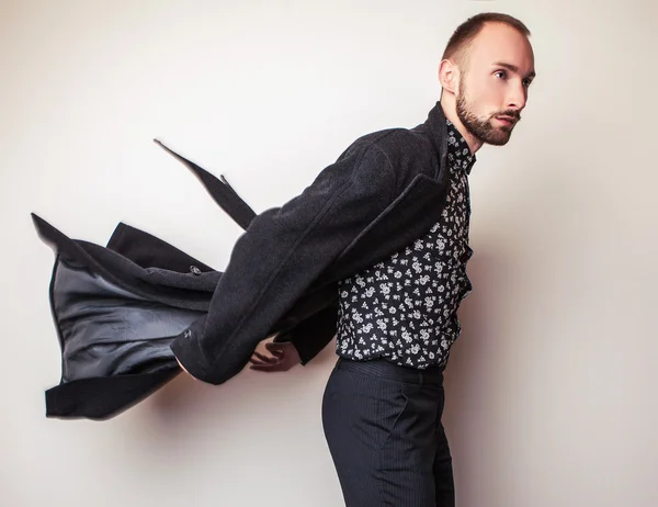 Elegante jonge knappe man in lang wollen jas. Studio mode portret. — Stockfoto