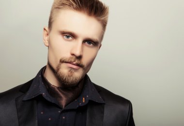 Siyah kostümlü zarif genç yakışıklı adam. Studio moda portre.