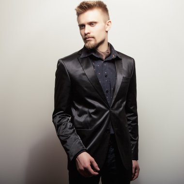 Siyah kostümlü zarif genç yakışıklı adam. Studio moda portre.