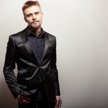 Siyah kostümlü zarif genç yakışıklı adam. Studio moda portre.